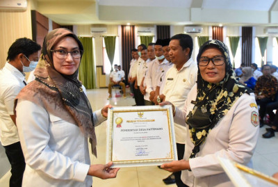 Bupati Luwu Utara, Indah Putri Indriani menyerahkan penghargaan indeks pembangunan Desa ke salah satu desa di Luwu Utara.