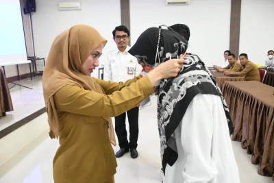 Bupati Luwu Utara, Indah Putri Indriani saat memasangkan atribut kepada peserta Bimtek Kementerian PUPR RI