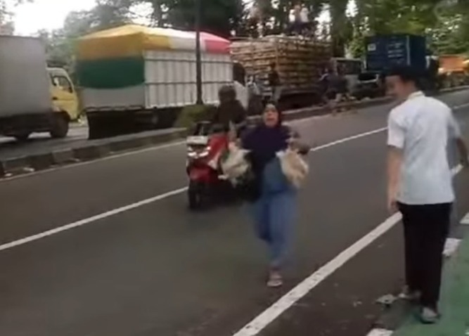 Tampak ibu-ibu usai serbu truk pengakut ayam yang terjebak macet di jalan poros Makassar -Maros.